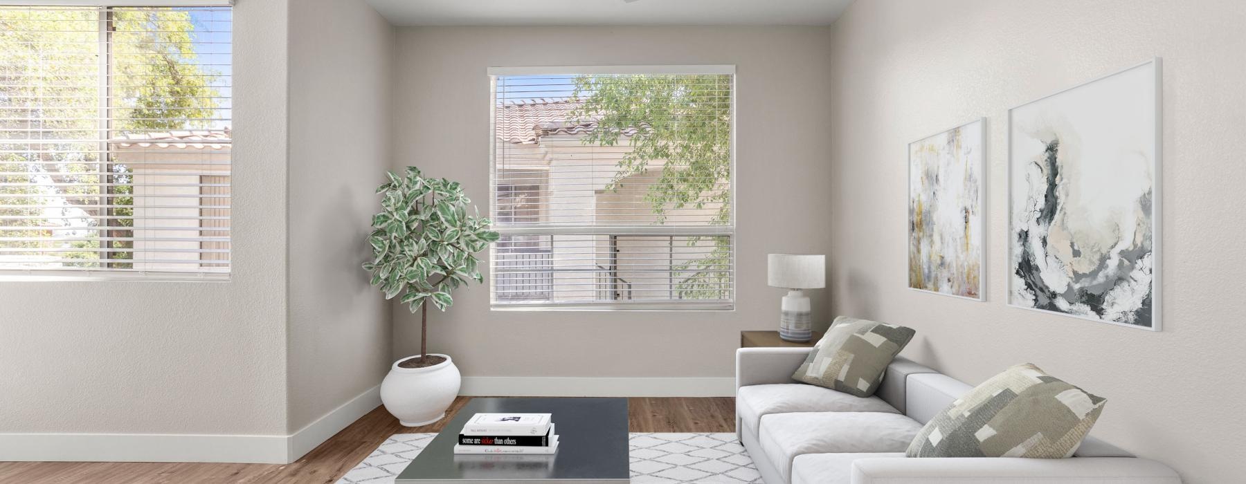 a living room with a white couch and a table with a plant