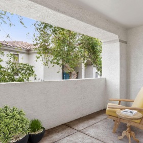 Your new home is waiting a patio with a chair and plants