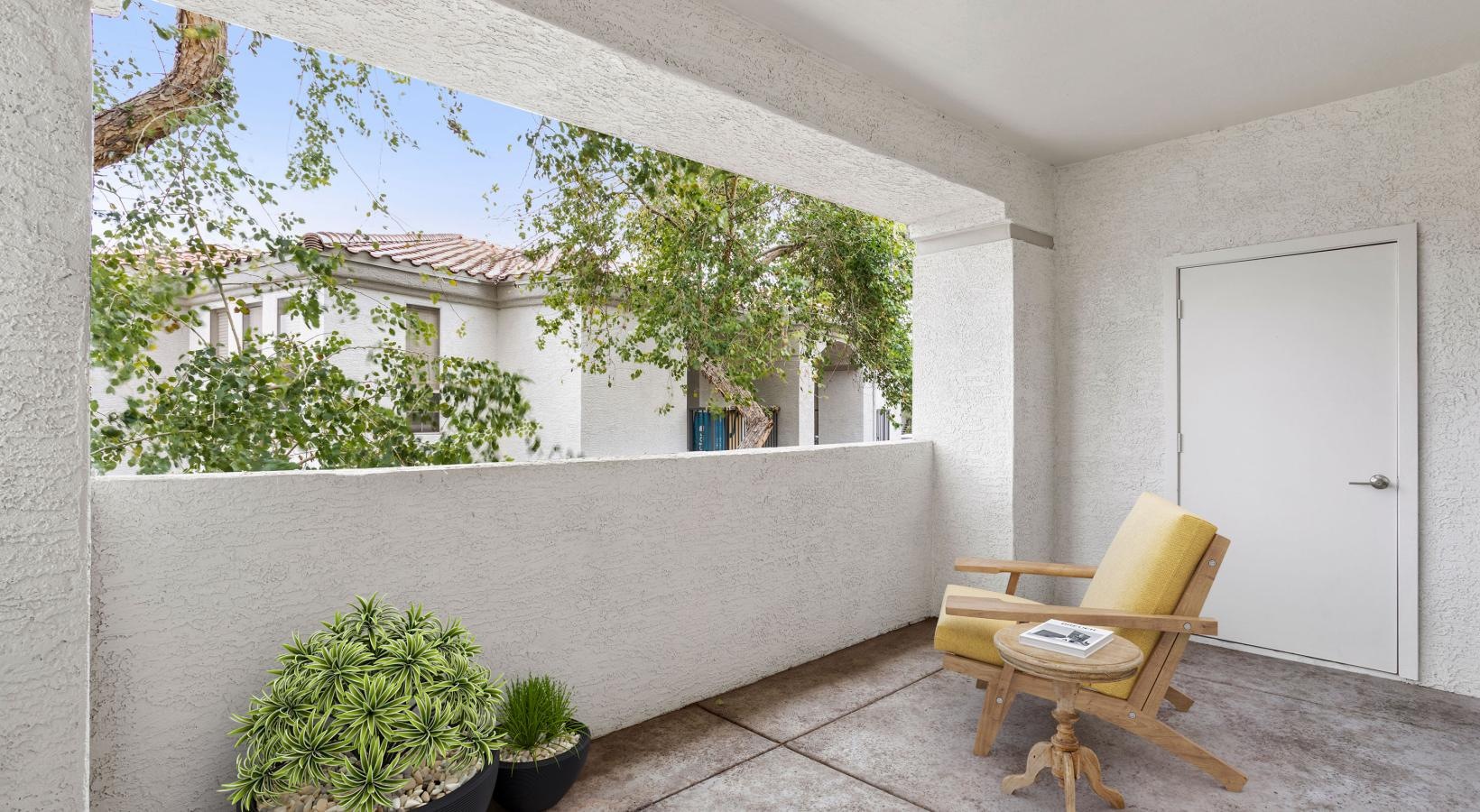 Your new home is waiting a patio with a chair and plants