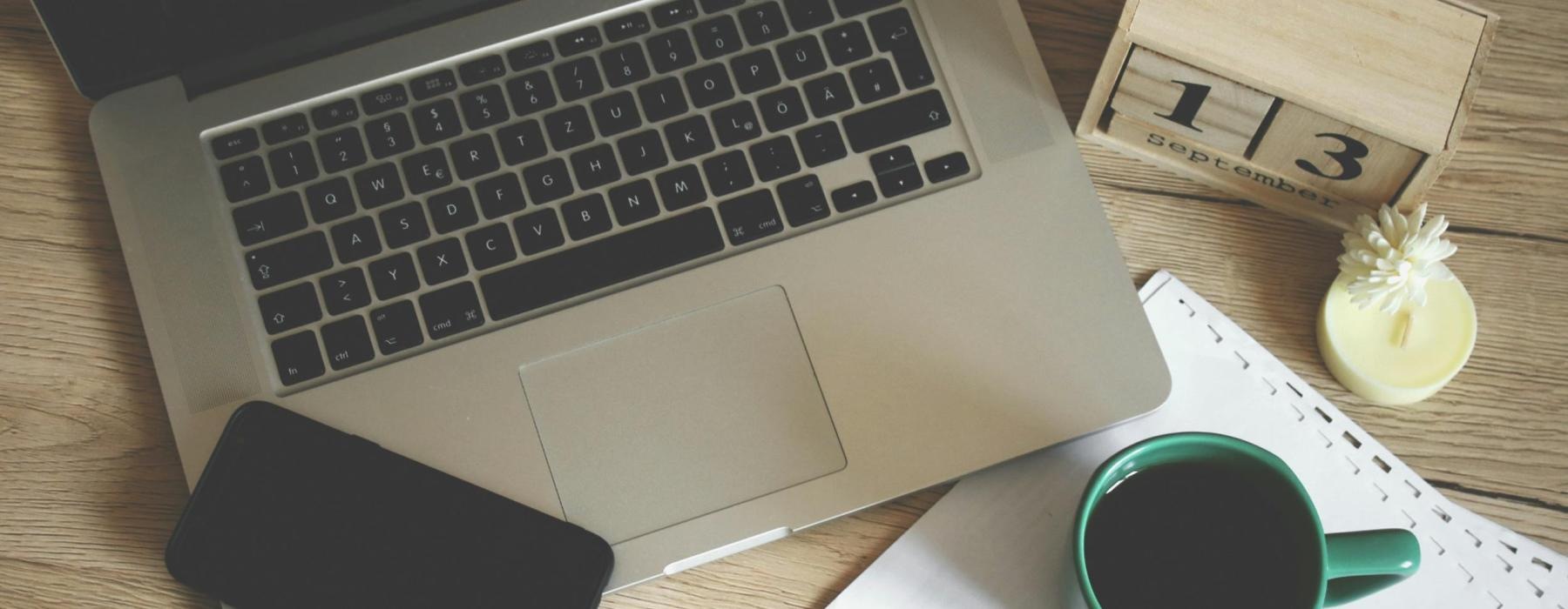 a laptop and a cup of coffee on a table